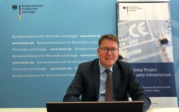 Dr. Zielke bei der Vorbereitungssitzung der Deutsch-Chinesischen Kommission Normung. Er sitzt vor einem Laptop, hinter ihm sind BMWi und GPQI Logos.