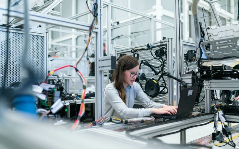 Woman in white long sleeve shirt using black laptop computer.