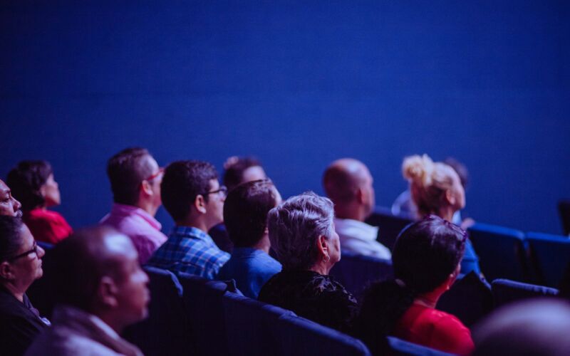 Menschen sitzen im Publikum und hören einem Vortrag zu