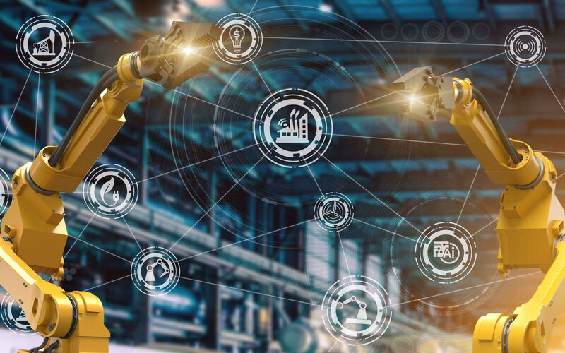 Gelbe Produktionsanlagen vor vernetzten Symbolen, die für die Digitalisierung der Industrie stehen.